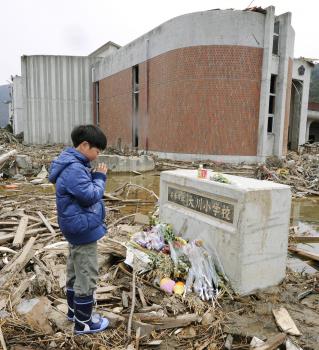 Chlapec sa modlí pri pamätníku obetí ZŠ v japonskom Išinomaki