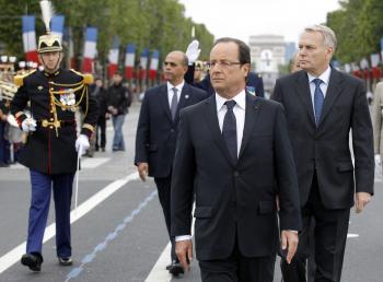 Prezident Hollande kráča pred vojenskými šíkmi v deň pádu Bastily