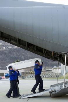 Policajti nakladajú rakvu do lietadla - ilustračné foto