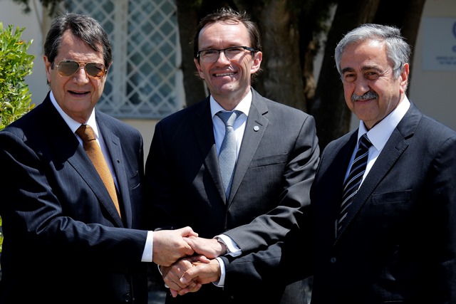 Na snímke cyperský prezident  Nicos Anastasiades (vľavo), líder cyperských Turkov Mustafa Akinci (vpravo) a špeciálny vyslanec OSN Espen Barth Eide (v strede) si podávajú ruky