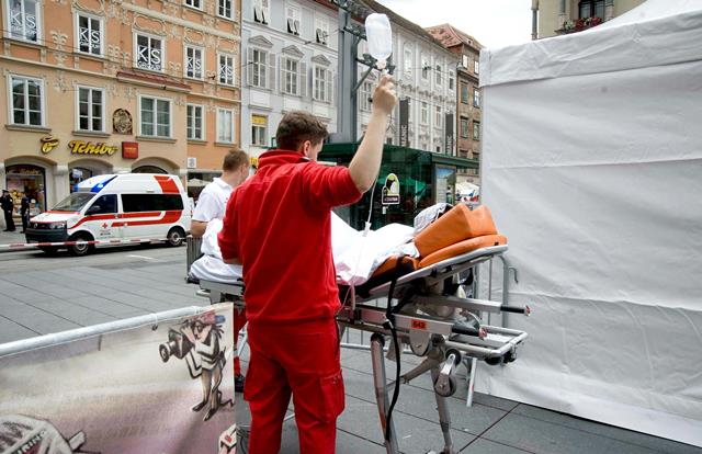 Na snímke záchranári odvážajú na nosidlách zraneného človeka na mieste nehody, kde vodič terénneho vozidla vrazil do davu ľudí v centre Grazu