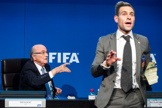 Na snímke vľavo prezident Medzinárodnej futbalovej federácie (FIFA) Sepp Blatter a vpravo britský komik Simon Brodkin s bankovkami v ruke počas tlačovej konferencie v Zürichu