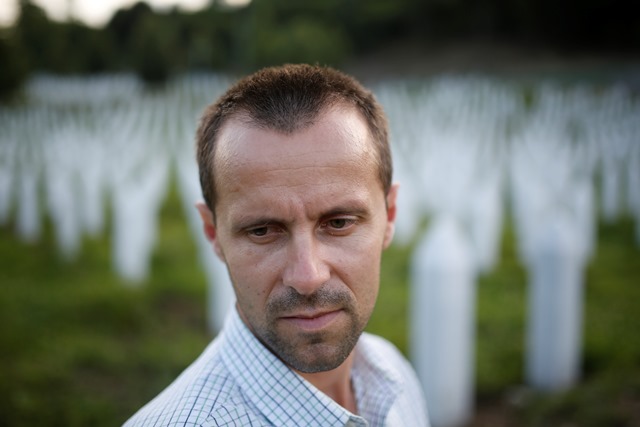 Na snímke 37-ročný Nedžad Avdič, ktorý prežil srebrenickú masakru, prechádza okolo hrobov obetí, ktorí sú pochovaní  v pamätnom centre srebrenickej masakry v bosnianskej obci Potočari, blízko Srebrenice