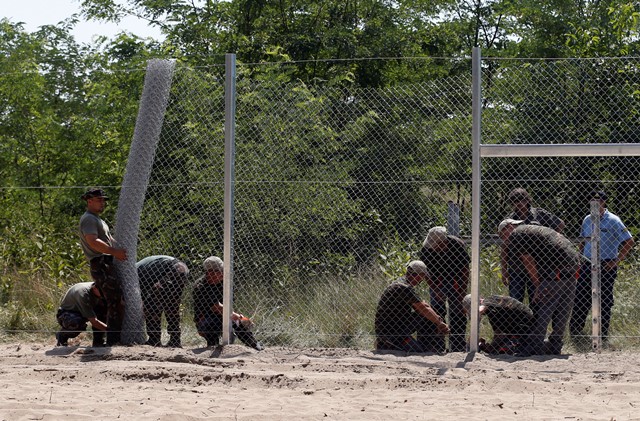 Na snímke príslušníci maďarských obranných síl počas výstavby dočasných zábran na maďarsko-srbských hraniciach 