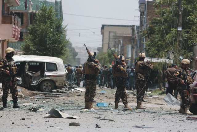 Afganské bezpečnostné jednotky hliadkujú na mieste útoku na konvoj zahraničných ozbrojených síl 7. júla 2015 v Kábule. Samovražedný útočník v afganskom hlavnom meste Kábul narazil s autom plným výbušnín do konvoja zahraničných ozbrojených síl
