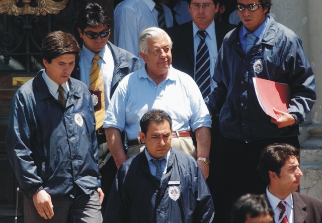  Na archívnej snímke z 28. januára 2005 Manuel Contreras (uprostred) odchádza zo sídla polície v Santiagu. Bývalý šéf obávanej tajnej služby v Čile, bol zodpovedný za únosy, mučenie a zavraždenie tisícov ľudí počas čilskej vojenskej diktatúry