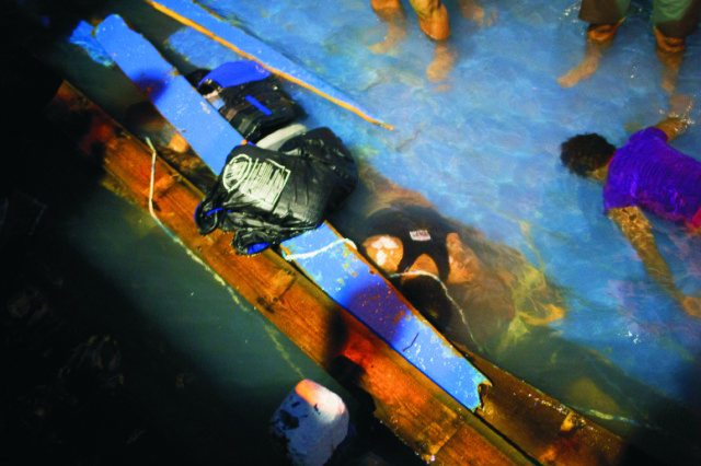 Na archívnej snímke záchranári vyťahujú mŕtve telá migrantov, ktorí sa utopili po prevrátení lode