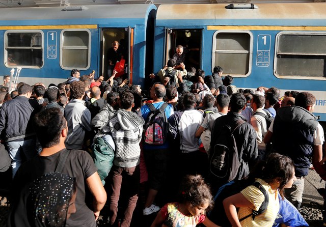 Na snímke migranti sa pokúšajú dostať do vlaku na nástupišti železničnej stanice Keleti v Budapešti