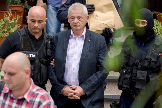 Na snímke policajti eskortujú zadržaného primátora Bukurešti Sorina Opresca z jeho domu v Ciolpani