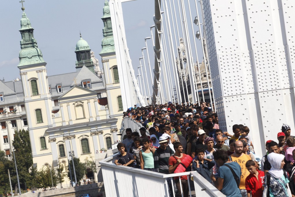 Niekoľko stoviek migrantov kráča po moste cez rieku Dunaj v Budapešti 4. septembra 2015 po tom, ako sa rozhodli ísť pešo do Rakúska