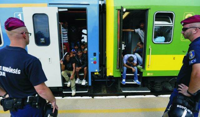 Na snímke policajti stoja pri vlaku s migrantmi, ktorý zastavili v maďarskom meste Bicske vo štvrtok 3. septembra 2015