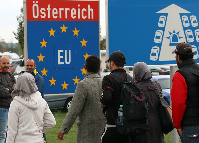 Na snímke migranti prechádzajú maďarsko-rakúskym hraničným priechodom v obci Nickelsdorf 