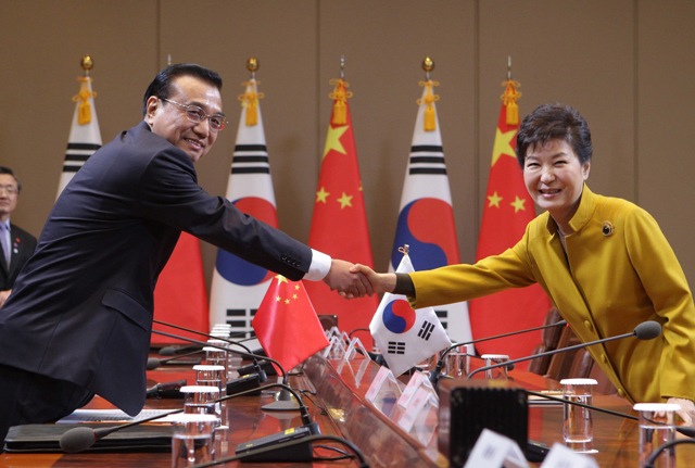 Na snímke juhokórejská prezidentka  Pak Kun-hje a čínsky premiér Li Kche-čchiang si podávajú ruky počas stretnutia pred bilaterálnym rokovaním v prezidentskom paláci v Soule 