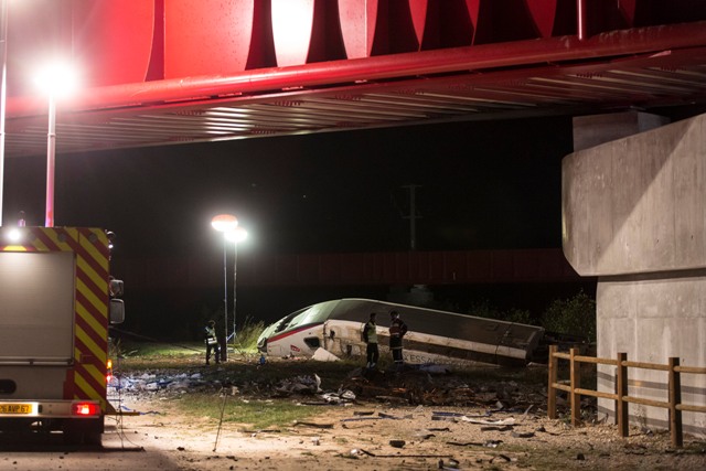 Na snímke záchranári stoja neďaleko vykoľajeného rýchlovlaku TGV vo francúzskom Eckerwersheime
