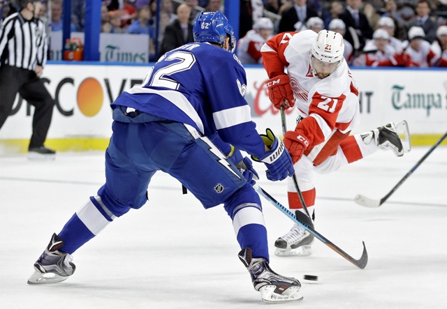 Hokejista Detroitu Red Wings Slovák Tomáš Tatar strieľa cez obrancu Tampy Bay Lightning Andreja Šustra z Českej republiky v zápase zámorskej hokejovej NHL