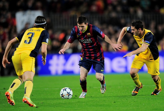 Hráč Barcelony Lionel Messi (v strede) uniká s loptou pred Filipeom Luisom (vľavo)
