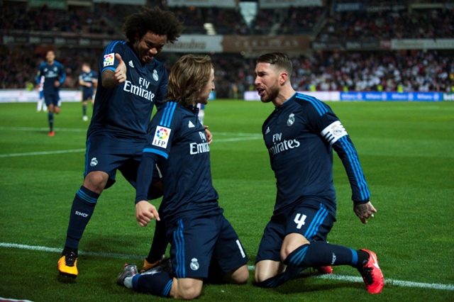 Hráč Realu Madrid Luka Modrič (uprostred) sa raduje so spoluhráčmi Marcelom (vľavo) a Sergiom Ramosom v zápase 23. kola španielskej futbalovej Primera division proti Granade