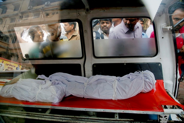 Na snímke ľudia pozerajú do sanitky na telá obetí Inda Hasnaina Warekara v indickom meste Thane