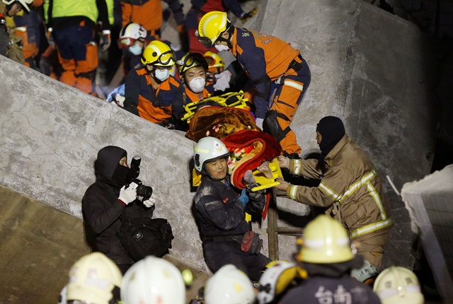 Na snímke záchranári vyťahujú žijúcu ženu z trosiek budovy