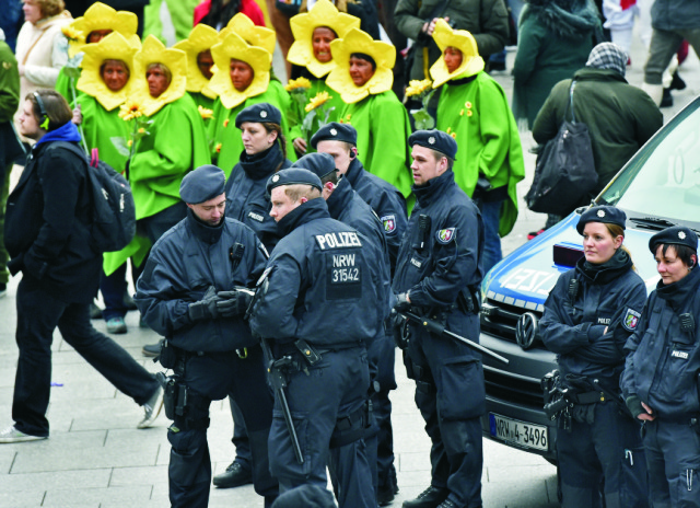 Policajti hliadkujú pred hlavnou železničnou stanicou účastníka počas začiatku pouličného karnevalu v Kolíne nad Rýnom 