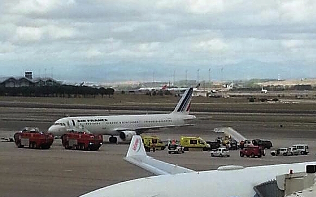 Na snímke hasičské autá a sanitky stoja pri lietadle francúzskych aerolínii Air France so 163 ľudmi na palube na letisku v Madride