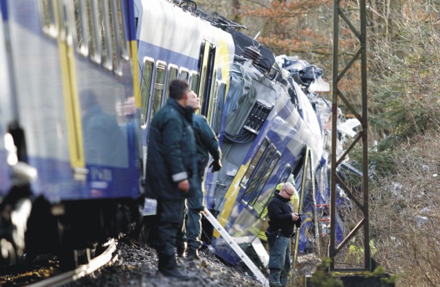 Na snímke polícia pri troskách vagónov na mieste zrážky dvoch vlakov v nemeckom Bad Aiblingu