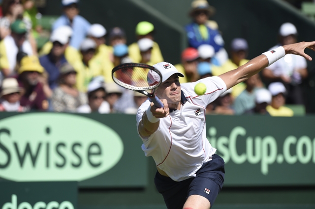 Americký tenista John Isner odvracia loptičku Austrálčanovi Bernardovi Tomicovi v tretej dvojhre zápasu 1. kola Davisovho pohára medzi tenistami Austrálie a USA