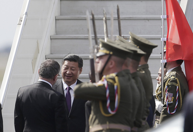Český minister zahraničných vecí Lubomír Zaorálek (vľavo) víta čínskeho prezidenta Si Ťin-pchinga (vpravo) pri vystupovaní z lietadla po jeho prílete na letisko v Prahe