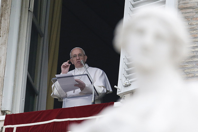 Pápež František stojí v okne počas modlitby na Veľkonočný pondelok na Námestí sv. Petra vo Vatikáne 28. marca 2016. 