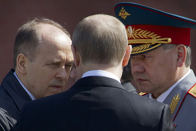 Ruský prezident Vladimir Putin (uprostred), šéf Federálnej bezpečnostnej služby Ruskej federácie (FSB) Alexander Bortnikov (vľavo) a šéf rezortu obrany Sergej Šojgu (vpravo)