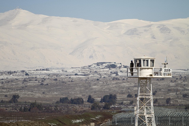 Na archívnej snímke vojenský príslušník OSN hliadkuje na stanovisku s výhľadom na  zasnežené Golanské Výšiny v blízkosti izraelsko-sýrskych hraníc