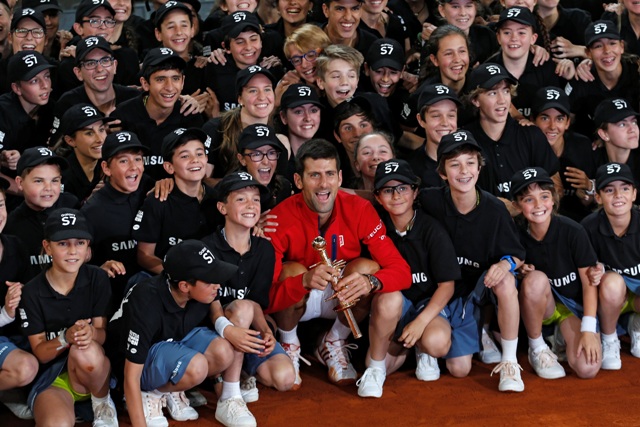 Srbský tenista Novak Djokovič (v červenom) pózuje s trofejou a zberačmi loptičiek po víťazstve vo finále mužskej dvojhry nad Britom Andym Murrayom na turnaji ATP Master 1000