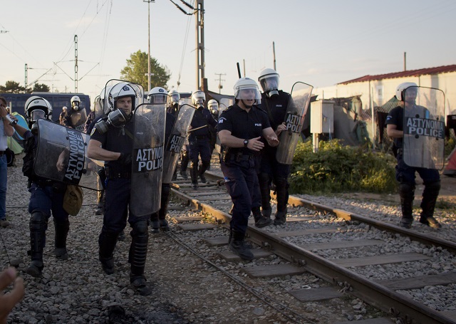 Grécki policaji počas kolízie s migrantami na macedónskych hraniciach v gréckej obci Idomeni