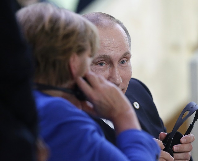 Na archívnej snímke vpravo ruský prezident Vladimir Putin a vľavo nemecká kancelárka Angela Merkelová 