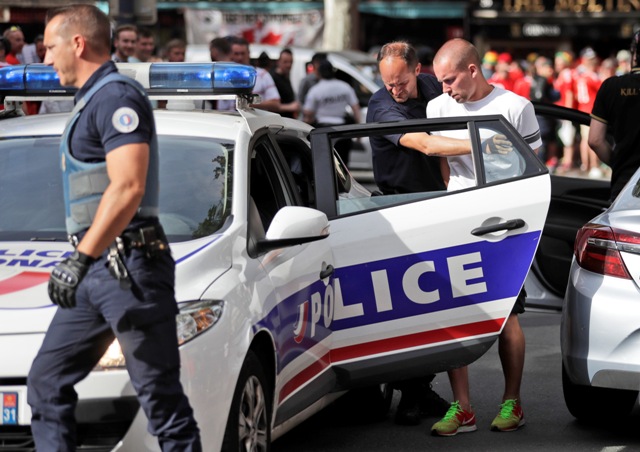 Na snímke francúzsky policajt vedie zatknutého ruského fanúšika pred zápasom B-skupiny na majstrovstvách Európy vo futbale medzi Ruskom a Walesom