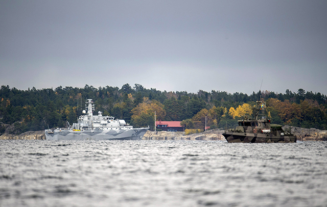 Švédska vojenská námorná loď HMS Kullen (vľavo) a plavidlo pobrežnej hliadky sa plavia v zálive Namdo Bay 21. októbra 2014 počas piateho dňa pátrania po podozrivom zahraničnom plavidle na Štokholmskom súostroví