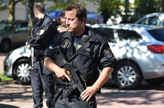 Na snímke policajti stoja pred vchodom do kina v nemeckom meste Viernheim