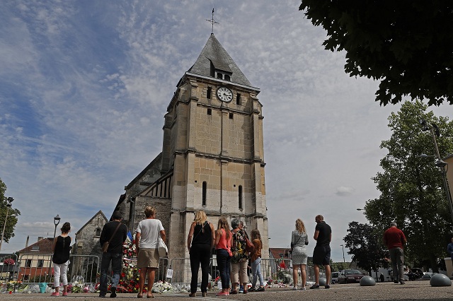 Ľudia sa zhromažďujú pri pamätníku pred kostolom v Saint-Etienne-du-Rouvray 28. júla 2016, v ktorom po útoku islamistov zahynul kňaz. Dvaja muži vyzbrojení nožmi vtrhli 26. júla do kostola v normandskom meste Saint-Étienne-du-Rouvray počas rannej omše, pričom zajali rukojemníkov a predtým, ako ich zlikvidovala polícia, podrezali hrdlo 84-ročnému kňazovi a ťažko zranili ďalšiu osobu. K zodpovednosti za útok sa prihlásila teroristická organizácia Islamský štát (IS)