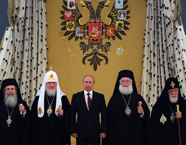 Na archívnej snímke ruský prezident Vladimir Putin (uprostred) a patriarcha moskovský a celej Rusi Kirill (druhý zľava) pózujú fotografom po stretnutí so zástupcami pravoslávnej cirkvi v moskovskom Kremli