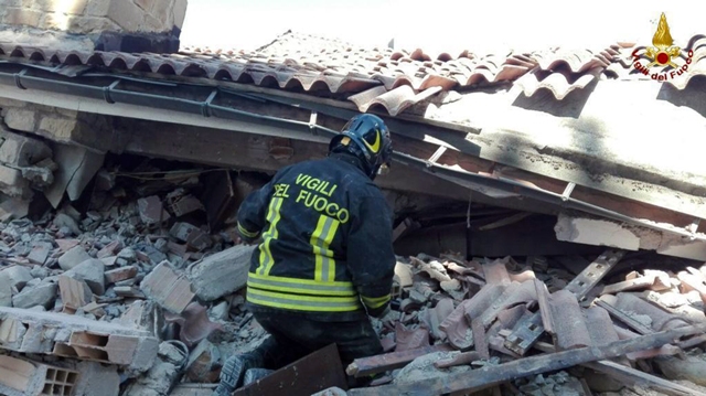 Hasič prehľadáva trosky zrútenej budovy po zemetrasení v meste Amatrice, v centrálnom Taliansku
