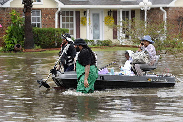 dobrovoľníci loďka ťahanie evakuovaná žena dieťa zaplavená ulica Baton Rouge