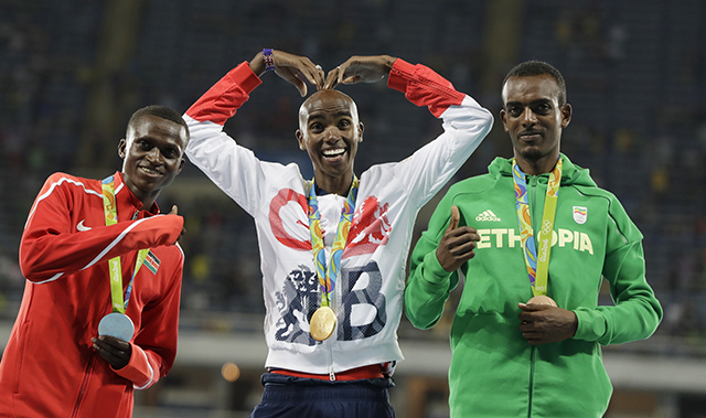 Na snímke uprostred britský vytrvalec Mo Farah obhájil zlatú olympijskú medailu v behu na 10.000 metrov na OH v Rio de Janeiro.  Striebro získal Paul Kipngetich Tanui z Kene (vľavo), bronz Tamirat Tola  z Etiópie (vpravo).