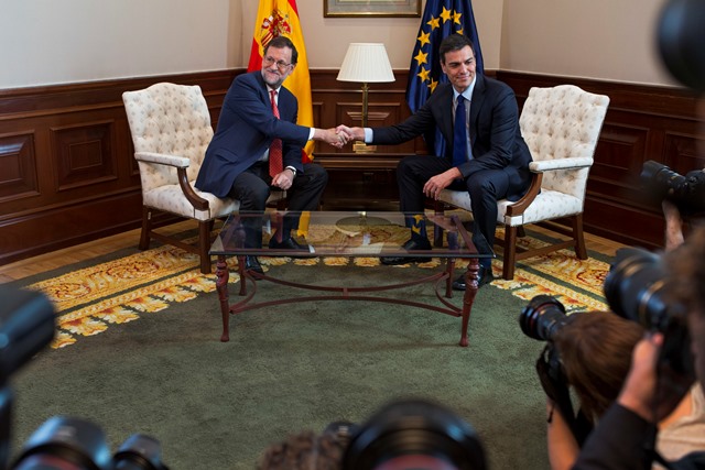Na snímke úradujúci španielsky premiér Mariano Rajoy (vľavo) si podáva ruku s lídrom Socialistickej strany Pedrom Sanchezom 