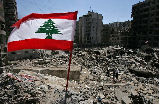 Libanonská zástava veje vo vetre nad troskami zbombardovaných budov