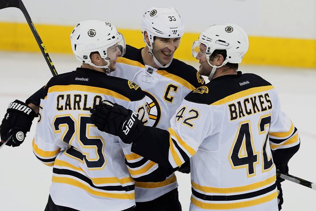 Hráč Bostonu Bruins Zdeno Chára (33) s raduje zo svojho gólu so spoluhráčmi  Brandonom Carlom (25) a Davidom Backesom počas zápasu zámorskej NHL proti Winnipegu