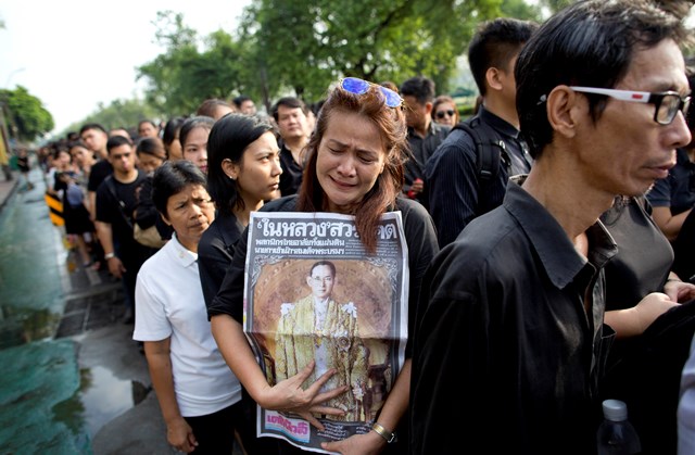 Na snímke plačúca Thajčanka drží portrét thajského kráľa Pchúmipchóna Adundéta počas čakania uctiť si jeho pamiatku