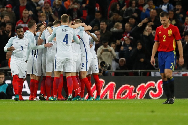 Na snímke vpravo Cesar Azpilicueta (Španielsko) prechádza okolo radujúcich sa hráčov Anglicka po úvodnom góle Adama Lallanu v prípravnom medzištátnom zápase Anglicko - Španielsko