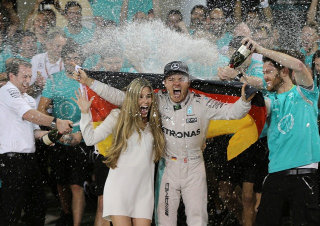 Nemecký pilot F1 na Mercedese Nico Rosberg oslavuje na pódiu s manželkou Vivian Siboldovou po tom, ako sa stal majstrom sveta Formuly 1 po pretekoch nedeľňajšej Veľkej ceny Abú Zabí na okruhu Yas Marina v Abú Zabí