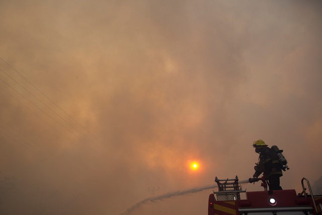 Na snímke hasič hasí požiar v Haife
