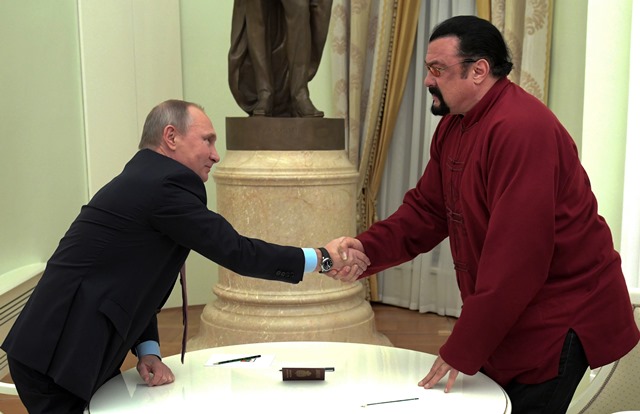 Na snímke ruský prezident Vladimir Putin a herec Steven Segal si podávajú ruky